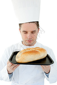一只闭着眼睛的男性厨师在面包上闻到味道图片