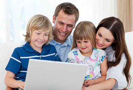 使用笔记本电脑微笑的家庭办公室爸爸孩子们房间夫妻技术帮助男生享受妈妈图片