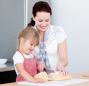 一个微笑的母亲和女儿在准备一顿饭的肖像吃饭男生时间蛋糕礼物糕点诱惑烹饪动画后代图片