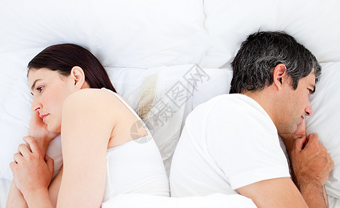 分开睡在床上的一对难堪的夫妇图片