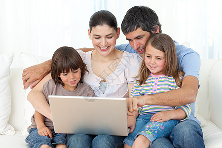 快乐的家庭在沙发上使用笔记本电脑图片