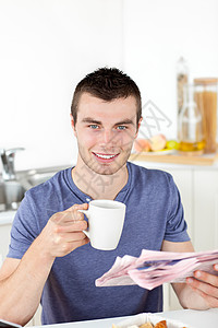 持着杯子和报纸笑着微笑着的青年男子男性网络商业成人牛奶阅读厨房自信咖啡羊角图片