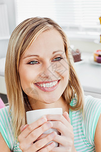 一位放松的女士拿着咖啡喝着一杯咖啡的肖像图片