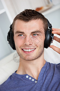 英俊的年轻人 用耳机听音乐背景图片