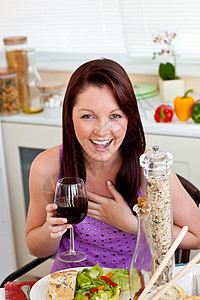 在家喝杯酒时吃着饭的开心女人图片