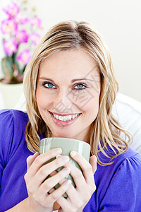 快乐的年轻女人 在沙发上喝咖啡图片