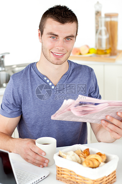 持着杯子和报纸笑着微笑着的青年男子商业文章男性食物领带男人饮料厨房笔记本网络图片