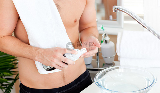 收紧一个年轻的肌肉男 准备在浴室刮胡子图片