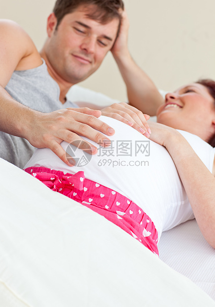 与丈夫躺在床上的孕妇快乐 幸福图片