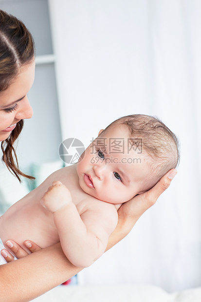 洗完澡后 一个小心妈妈抱着婴儿的肖像图片
