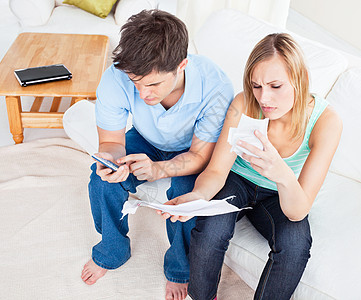 在沙发上坐着一对重夫妻在家中计算账单图片