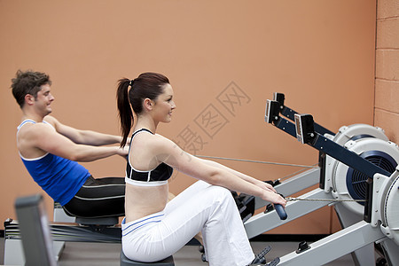 年轻夫妇在体育中心用划轮机图片