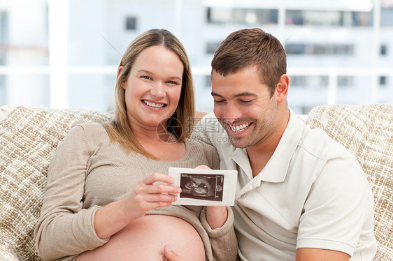美丽的怀孕孕妇向丈夫展示她的回声法 以示她的丈夫图片