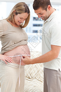 偷窥者测量其怀孕妻子的腰部图片
