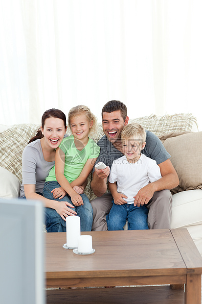 欢乐的家庭在看电视时大笑着坐在S上图片