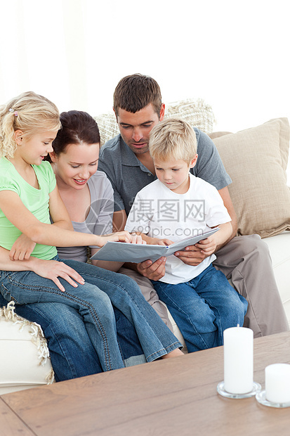 幸福的一家人看着相片专辑 坐在一起图片