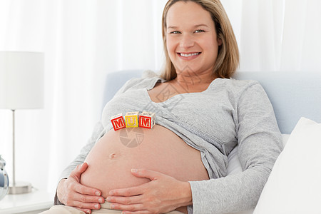 快乐的怀孕女人 妈妈在肚子上写信 在放松的时候图片