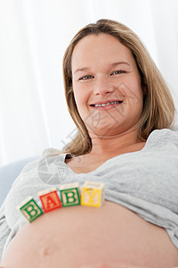 未来母亲肚子上挂着婴儿字母的肖像图片