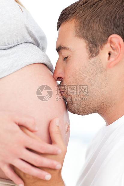 未来的父亲亲吻他怀孕妻子的肚腹图片