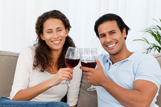 沙发上几杯红酒连着一副玻璃的肖像妻子女性庆典黑发男人微笑房间客厅男性夫妻图片