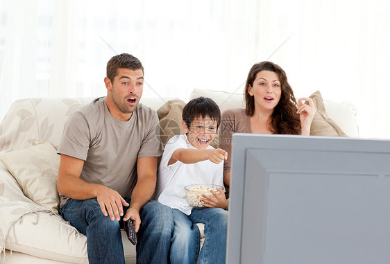幸福的家庭在沙发上一起看电视的电影图片
