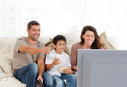 家庭在一起看电视时大笑爸爸幸福电视节目孩子程序玉米男生母亲乐趣沙发图片