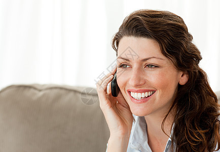 美丽的女人在电话里说话微笑客厅黑发房子商务快乐人士喜悦讲话手机图片
