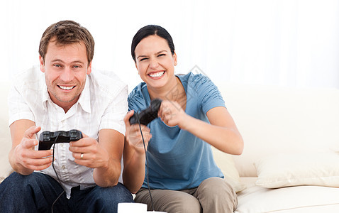 在沙发上和她男朋友玩电子游戏的 开心女人图片