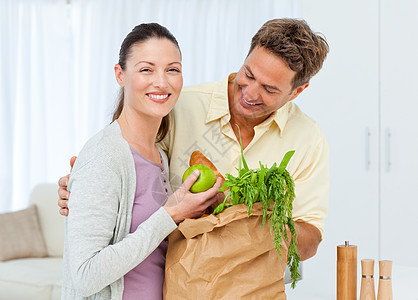 快乐的一对夫妇从市场回来 带水果蔬菜图片