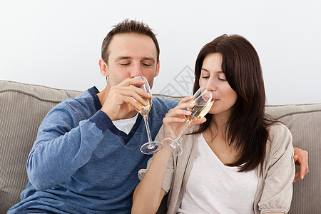 放松的情侣在沙发上喝香槟图片