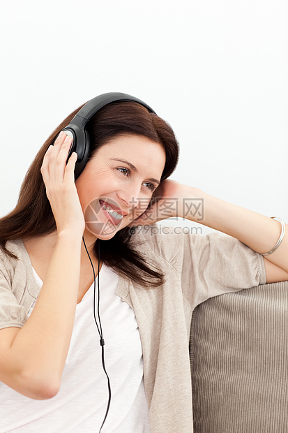 女人在沙发上聆听音乐时微笑图片