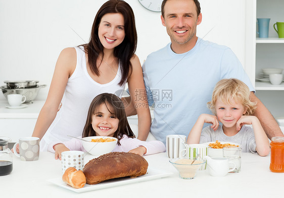 在厨房一起吃早饭的 幸福的家庭啊图片