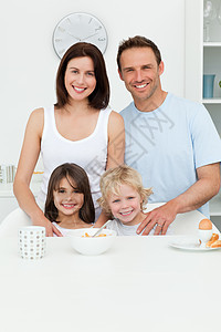 快乐的父母在厨房里冒着孩子的笑容图片