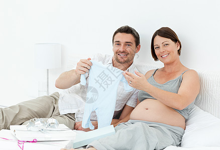 年轻未来的父母穿着乳衣幸福母性卧室说谎母亲喜悦夫妻怀孕妻子男人图片