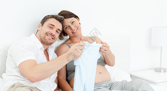 年轻未来的父母穿着乳衣微笑享受母性腹部几个月幸福怀孕妻子男性母亲图片