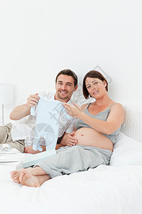 年轻未来的父母穿着乳衣怀孕腹部父亲男性婴儿幸福爸爸夫妻情感说谎图片