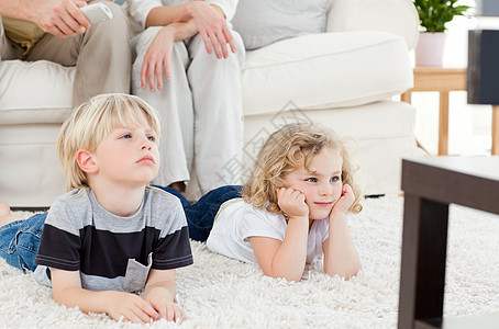 可爱的家庭观看电视妻子食物父亲沙发母亲孩子女儿妈妈电视节目男生图片