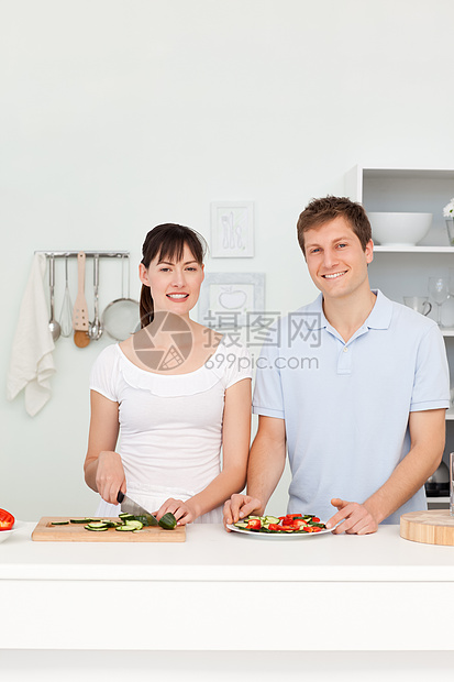 年轻一对看镜头的年轻夫妇洋葱午餐菜肴平底锅乐趣幸福女士烹饪勺子男人图片