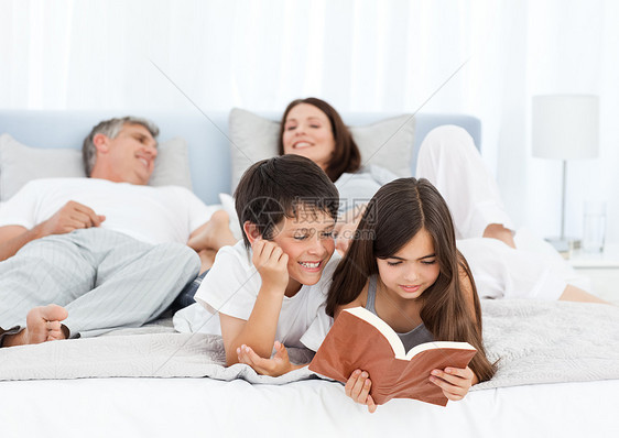 父母在孩子看书时说话 而他们的孩子在读书家庭父亲男人儿子女儿妈妈感情团体生活卧室图片