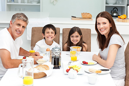 家人在厨房吃早饭父母童年孩子橙子女孩幸福生活享受女性房子图片