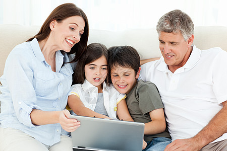 家庭看笔记本电脑父亲孩子男人丈夫女孩妈妈技术母亲作业帮助图片