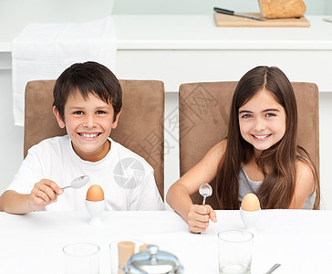 孩子们在厨房里吃早饭孩子小吃午餐快乐女孩早餐桌子青年食物勺子图片
