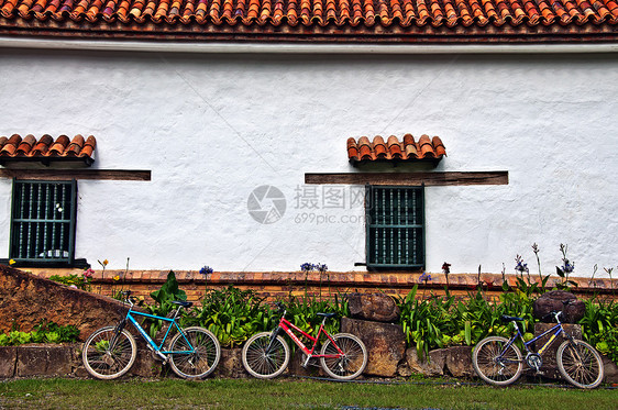 三个自行车停靠在墙壁上图片