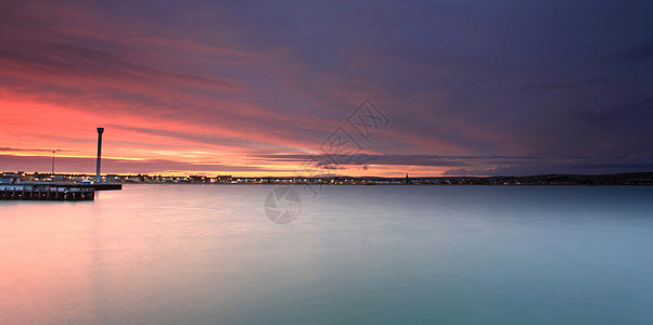 英国威茅斯海滨日落太阳波浪蓝色天空港口海滩海洋日出海岸图片