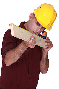 测量一块木柴的木匠头盔工程师男性木材建筑师工程木板维修员工统治者图片