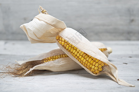 木头背景上的玉米耳朵图片