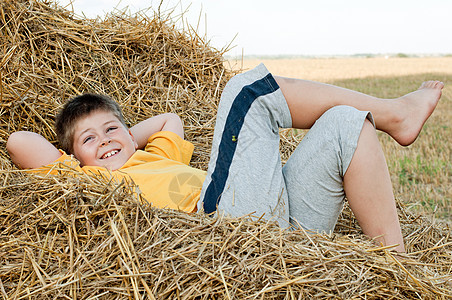 男孩躺在稻草上村庄童年休息生活女性农场草地乡村国家黄色图片
