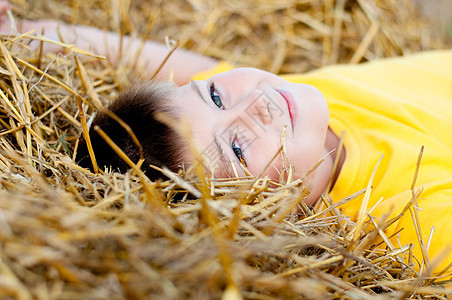 男孩躺在稻草上孩子场地村庄乡村生活休息说谎国家农业农场图片