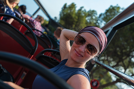 在太阳镜和波达纳的旅游巴士上微笑的女人图片