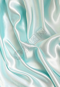 平滑优雅的蓝色丝绸作为背景布料银色折痕曲线投标织物海浪白色材料纺织品图片